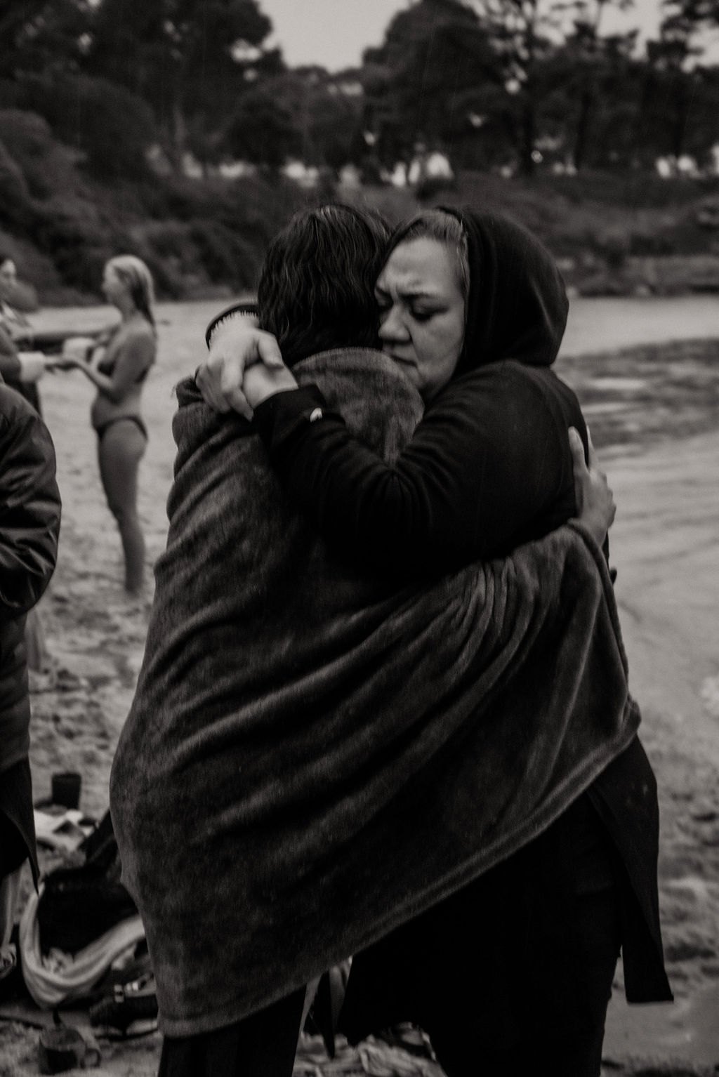 Two women embracing during a beach gathering