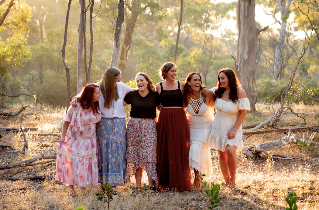 Women standing together in golden light in nature