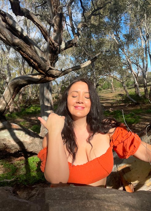 Janelle Bridge in an orange top outdoors
